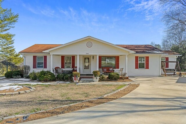 ranch-style home featuring covered porch and driveway