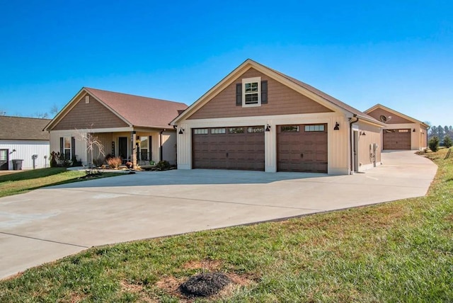 view of front facade with driveway, board and batten siding, and a front yard