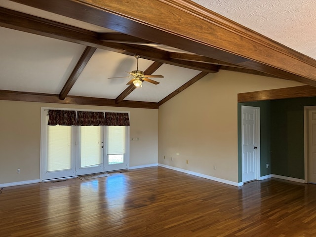 empty room with a ceiling fan, vaulted ceiling with beams, wood finished floors, and baseboards