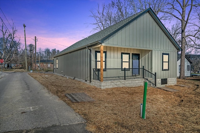 view of front of house featuring a porch, crawl space, a shingled roof, and board and batten siding