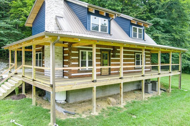 view of front of house featuring stairway, metal roof, a chimney, and central AC unit