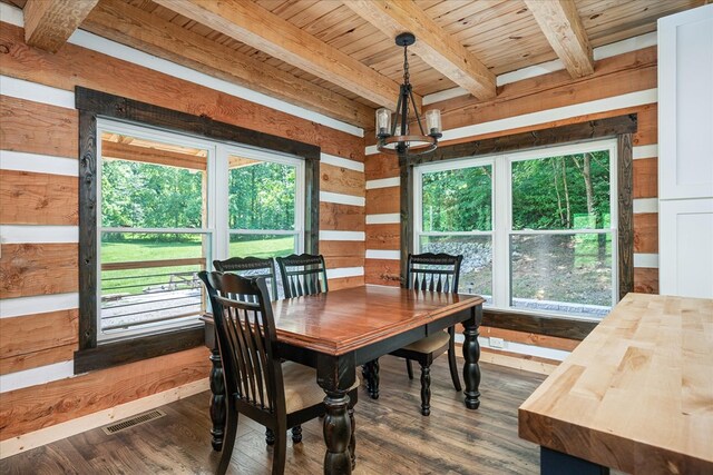 dining area featuring visible vents, dark wood finished floors, wooden ceiling, an inviting chandelier, and beam ceiling