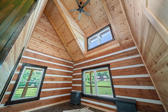 interior space featuring a skylight, wooden ceiling, ceiling fan, wood walls, and beam ceiling