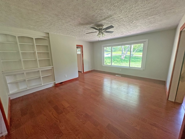 interior space with a textured ceiling, a ceiling fan, baseboards, and wood finished floors