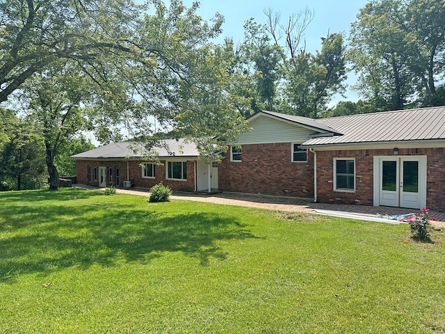 back of house featuring a yard and brick siding