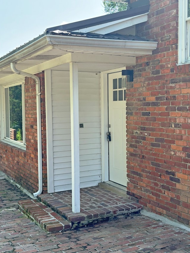 view of exterior entry with brick siding