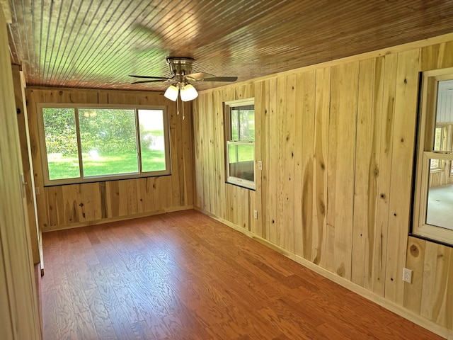 spare room with a ceiling fan, wood ceiling, wood finished floors, and baseboards