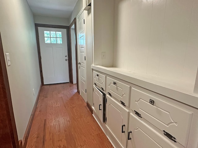 doorway with light wood-style floors and baseboards