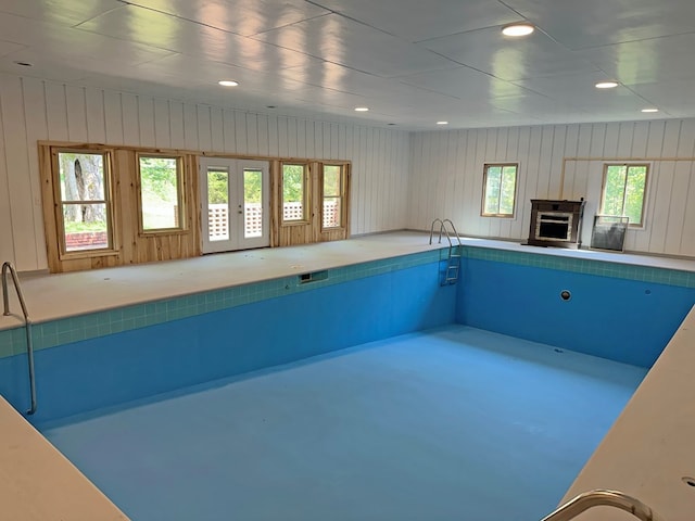 view of pool with french doors and a fireplace