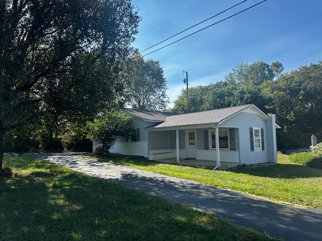 view of front facade with a porch, driveway, and a front lawn