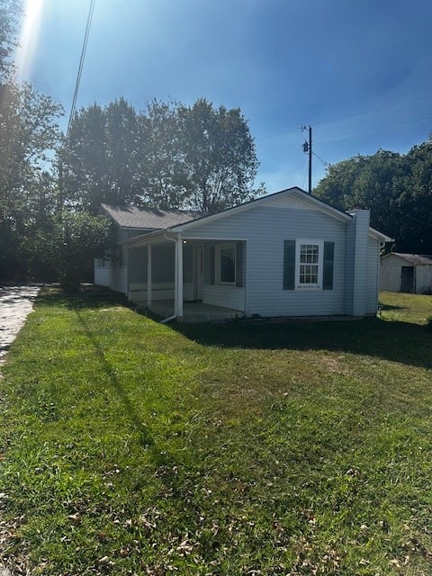 back of house with a lawn