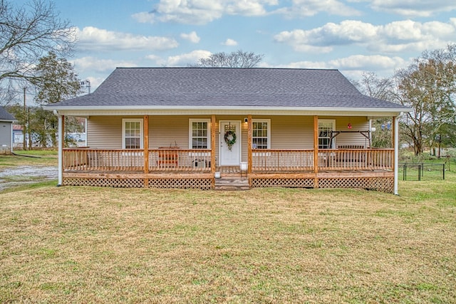 country-style home with a porch, roof with shingles, and a front yard