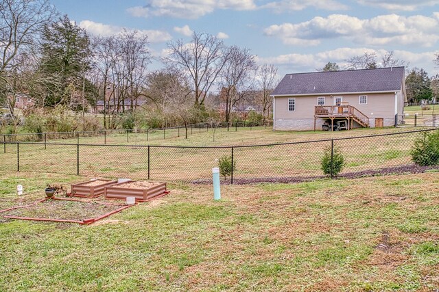 view of yard with fence private yard, a garden, stairway, and a deck