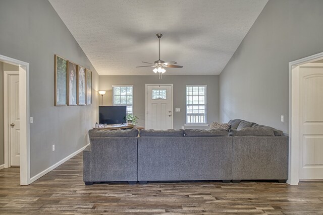 unfurnished living room with lofted ceiling, ceiling fan, a textured ceiling, and dark wood-style flooring