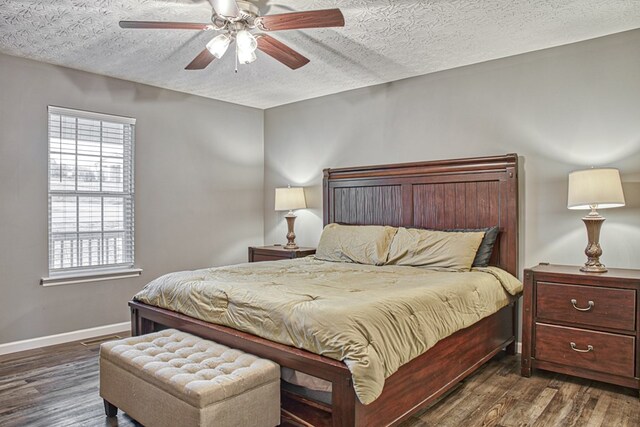 bedroom featuring a textured ceiling, visible vents, a ceiling fan, baseboards, and dark wood-style floors