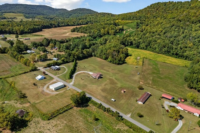 birds eye view of property featuring a forest view and a mountain view