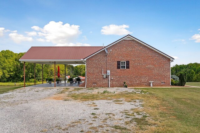 view of home's exterior featuring metal roof, a yard, brick siding, and crawl space