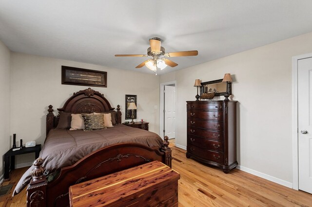 bedroom featuring ceiling fan, light wood-style flooring, and baseboards