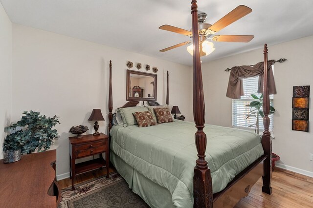 bedroom featuring a ceiling fan, baseboards, and wood finished floors