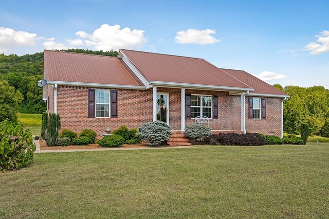 single story home featuring metal roof, a front lawn, and brick siding