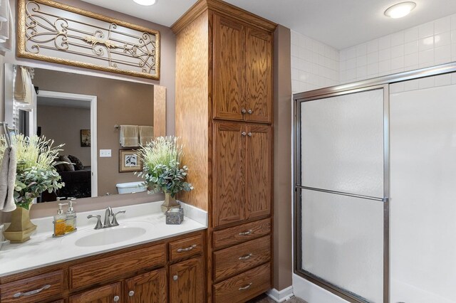 full bathroom with toilet, a shower stall, and vanity