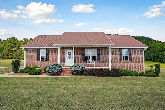 ranch-style home featuring metal roof, brick siding, and a front lawn