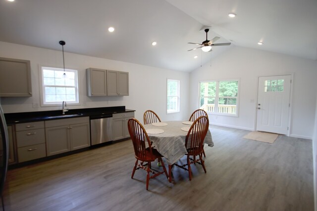 dining room with a healthy amount of sunlight, baseboards, wood finished floors, and lofted ceiling