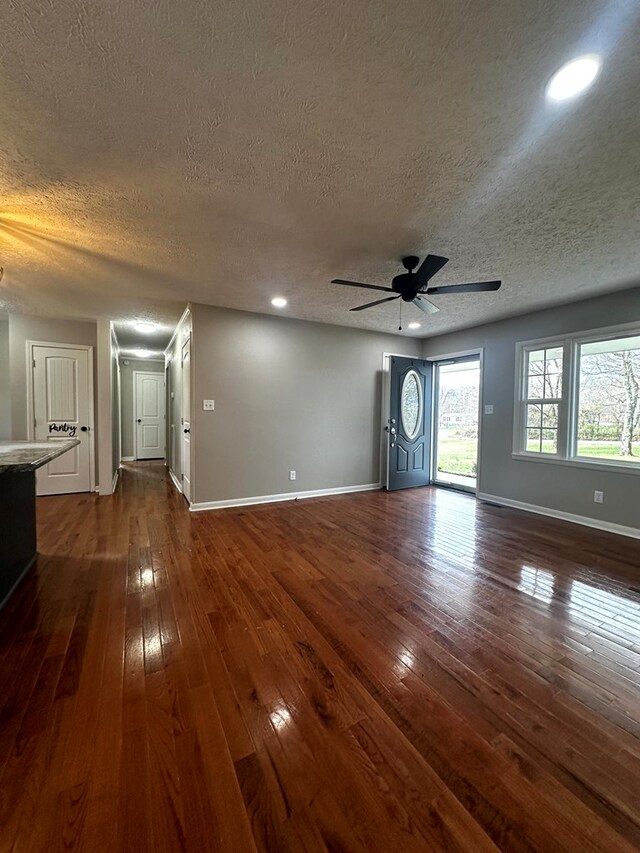 unfurnished living room featuring dark wood-style floors, ceiling fan, baseboards, and recessed lighting