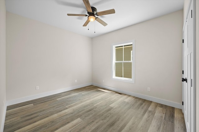 unfurnished room featuring ceiling fan, light wood-style flooring, and baseboards