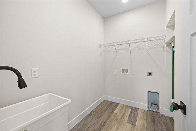 laundry room with hookup for a washing machine, hookup for an electric dryer, laundry area, wood finished floors, and a sink