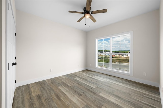 unfurnished room featuring light wood-style floors, visible vents, and baseboards