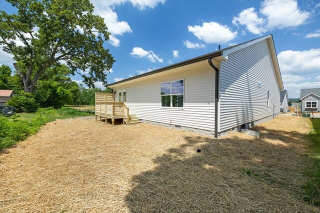 view of side of home with crawl space and a deck