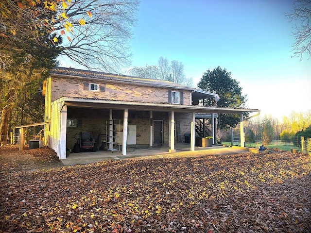 rear view of property with cooling unit and brick siding