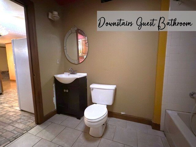 bathroom featuring tile patterned floors, vanity, toilet, and baseboards