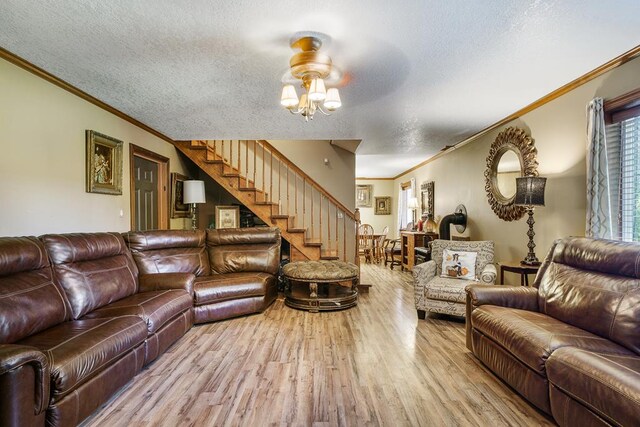 living area with light wood-type flooring, crown molding, stairway, and a textured ceiling