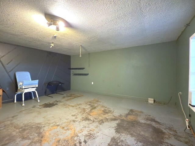 unfurnished room with unfinished concrete flooring and a textured ceiling