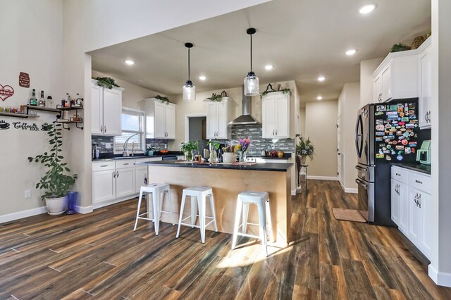 bathroom with double vanity, wood finished floors, a sink, and recessed lighting