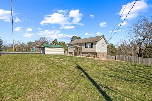 bi-level home featuring driveway, a front yard, and fence
