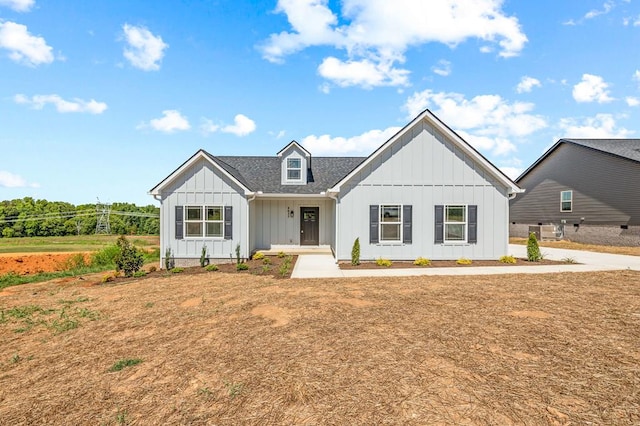 modern farmhouse with roof with shingles, board and batten siding, and central air condition unit