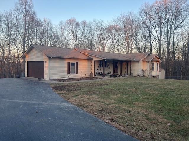 single story home featuring a garage, a lawn, and covered porch