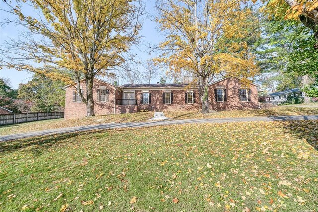 single story home with a front yard, brick siding, and fence