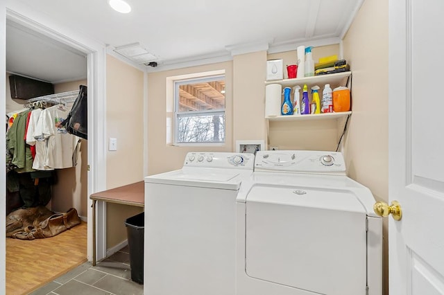 clothes washing area featuring light wood-type flooring, laundry area, and washer and dryer