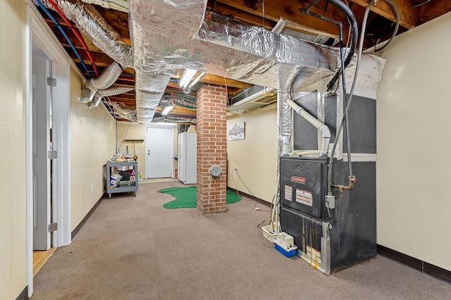 unfinished basement featuring heating unit and baseboards