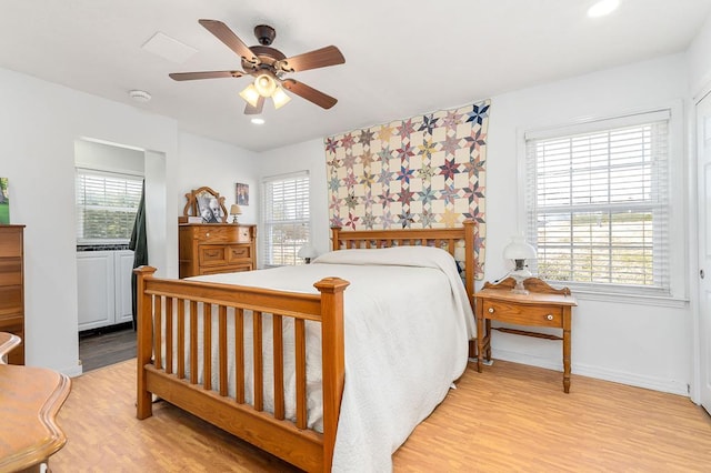 bedroom featuring multiple windows, light wood-type flooring, and baseboards