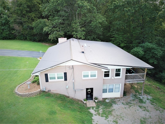 view of home's exterior featuring dirt driveway, a yard, and a chimney