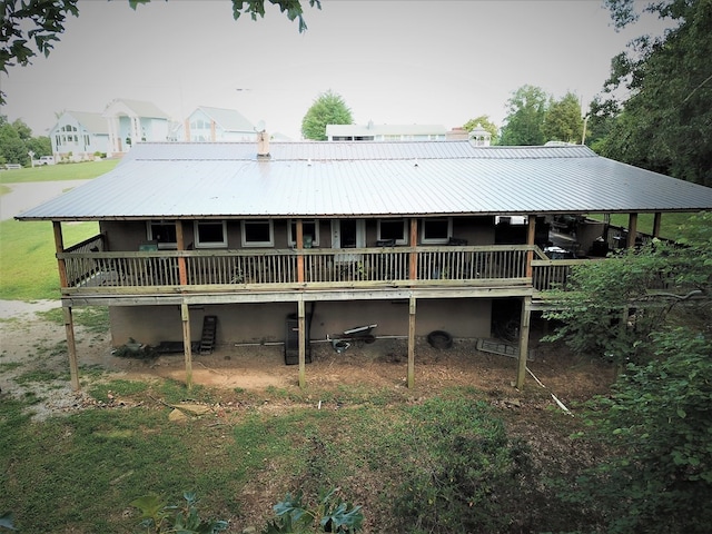 rear view of house featuring a deck and metal roof