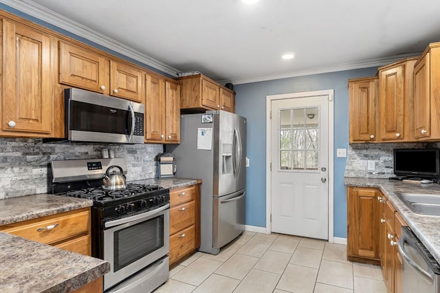 kitchen with light tile patterned flooring, stainless steel appliances, tasteful backsplash, brown cabinetry, and crown molding