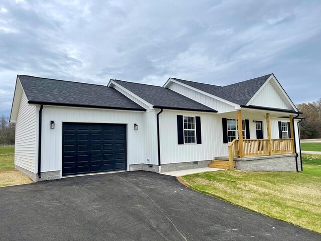 modern farmhouse style home with aphalt driveway, a garage, covered porch, a shingled roof, and crawl space