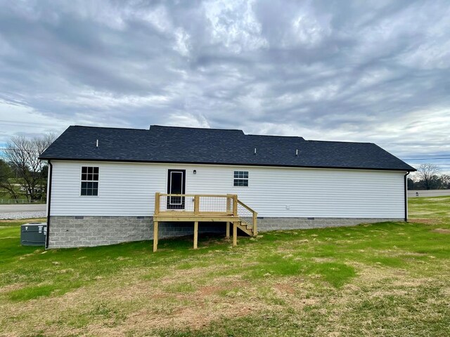 rear view of property featuring a yard, a shingled roof, crawl space, and a wooden deck