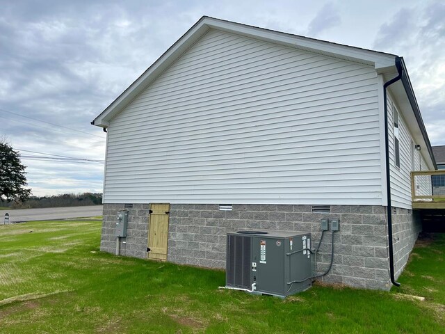 view of property exterior featuring central air condition unit, crawl space, and a lawn